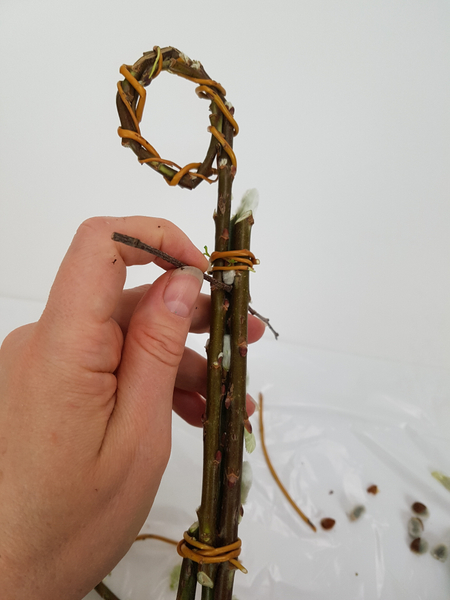 Push the first horizontal stem through the twig bundle