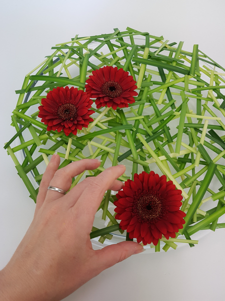 Cut the flower stems short and set it in the water.