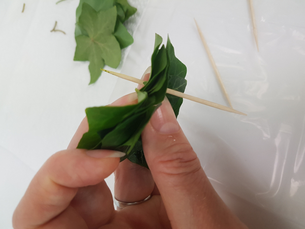 Pierce the leaves with the bamboo skewer.  The idea is to pierce the leaves in a triangle.