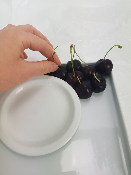 Place cherries all around the plate, stems facing up.