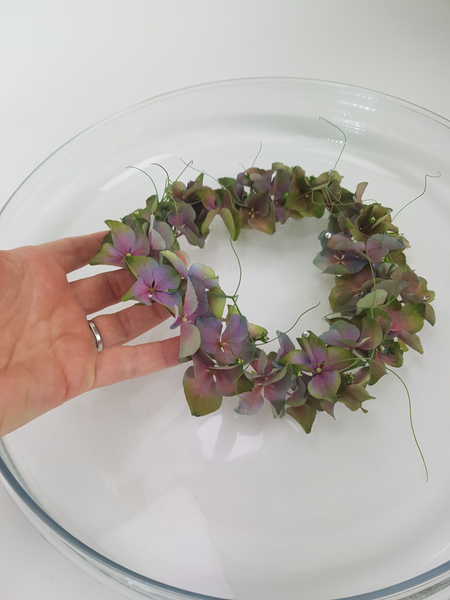 Set the hydrangea wreath on the water to float in the shallow container.