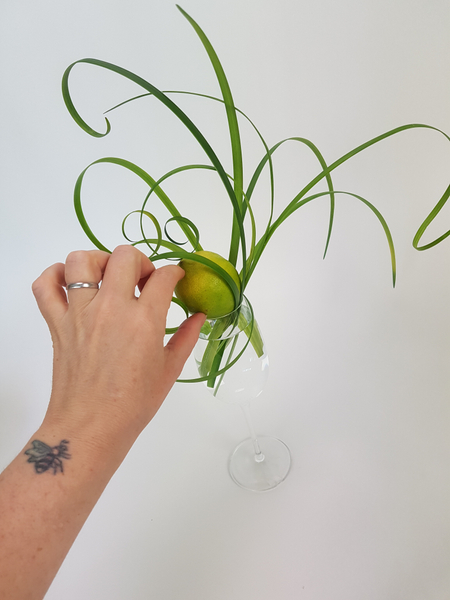 As you build up the design set the lemon at a slight angle so that the plant material are kept in place but not squished between the glass and lemon. 