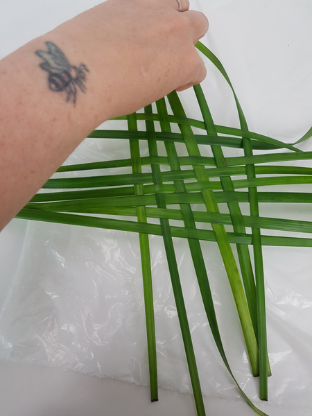 Weave in blades of grass to almost the size of your container.