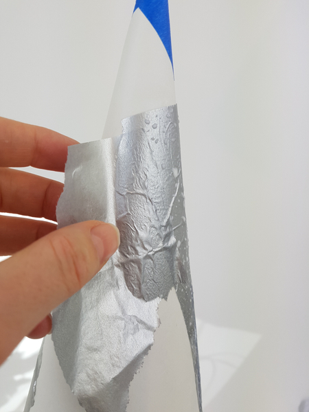 Paint the cardboard cone with thinned glue and smooth on the tissue paper