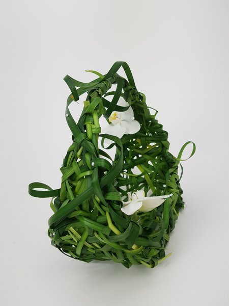 Floral arrangement of woven grass and orchids Floral arrangement of woven grass and orchids