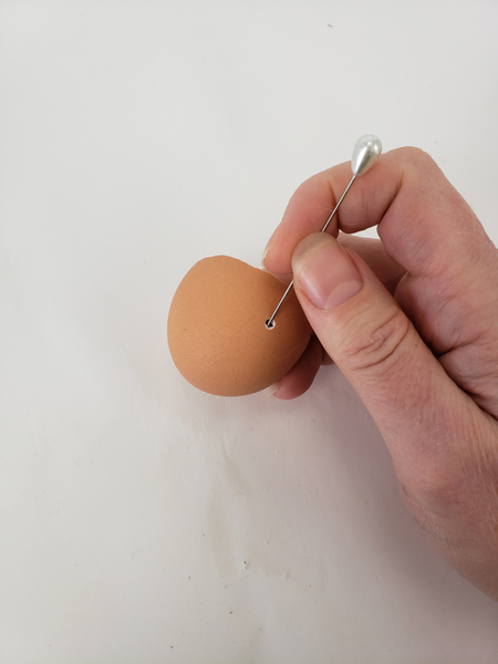 Pierce a small hole in an eggshell