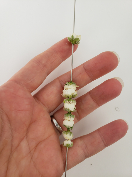 Thread in the largest blossom for the caterpillar head