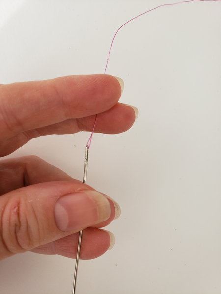 Thread the wire through the eye of a lei making needle
