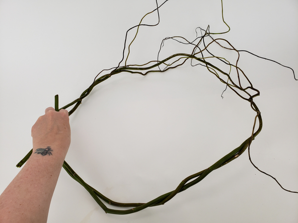 Bend willow branches to shape the wreath