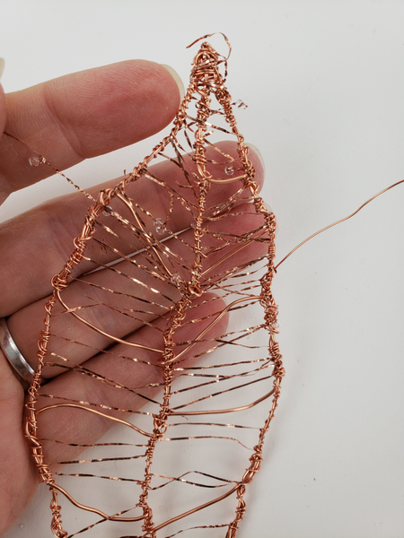 Weave the beaded wire in and around the copper wire leaf