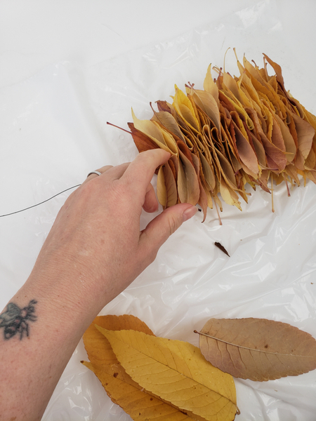 Building up a pretty fall leave garland with a fold in the middle