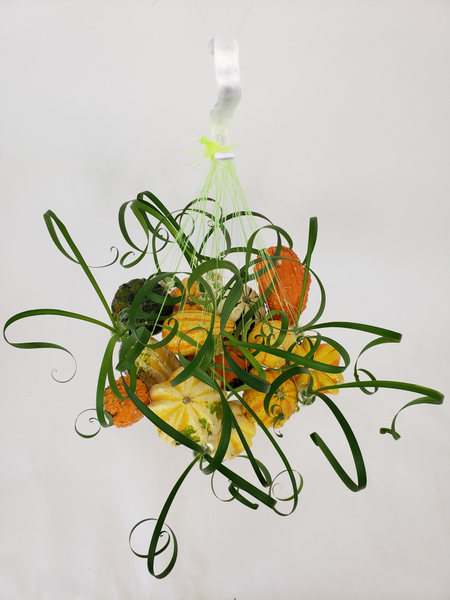 Hanging pumpkins in a flower arrangement by Christine de Beer