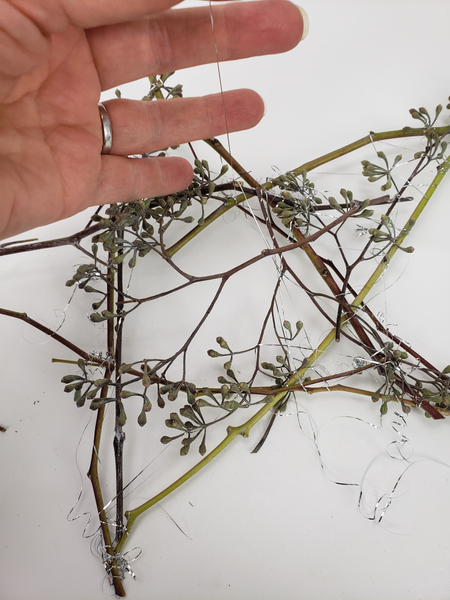 Tie the stems and seedpods with tinsel and curl the tinsel ends