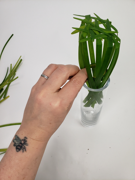 Slip the grass into the vase so that it is between the grass circle and the glass