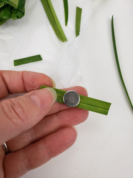 Glue a corsage magnet to a blade of grass
