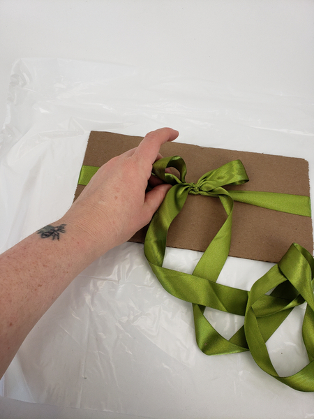 Tie a ribbon bow around the cardboard