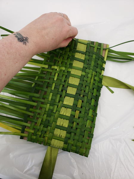 Weaving in strand after strand of grass
