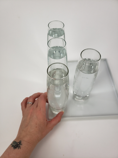 Place water filled bud vases of a display tray