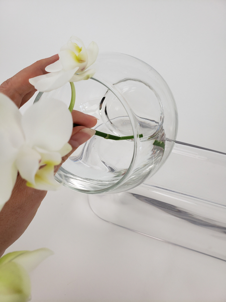 Hook the stem over the top lip of the vase