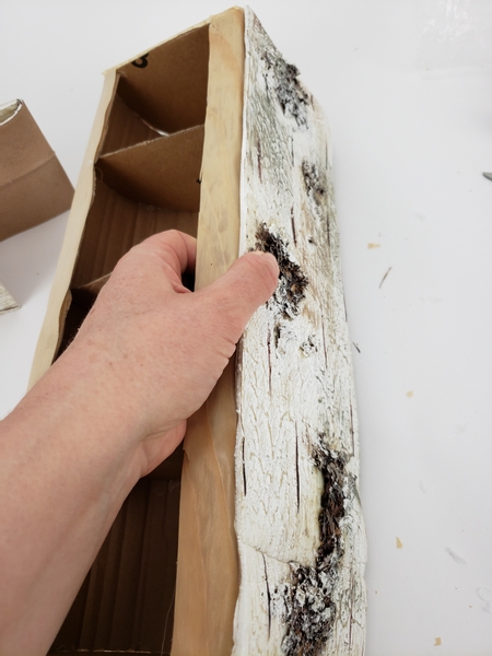 Fit the bark to the side of the paper log and glue down with a generous amount of hot glue