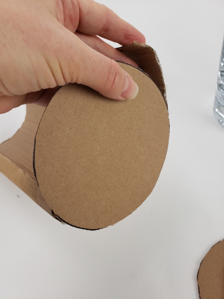 Glue one cardboard disk to one end