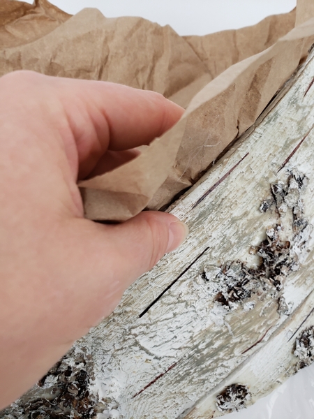 Glue the edge of the bark to the brown paper