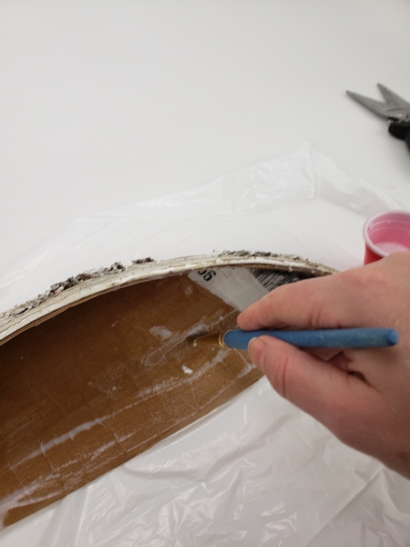 Paint the inside of the cardboard half moon with thinned wood glue