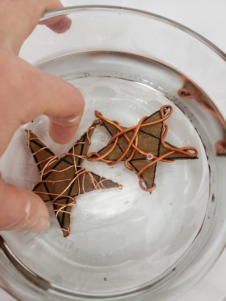 Soak the wire and cardboard stars in warm water