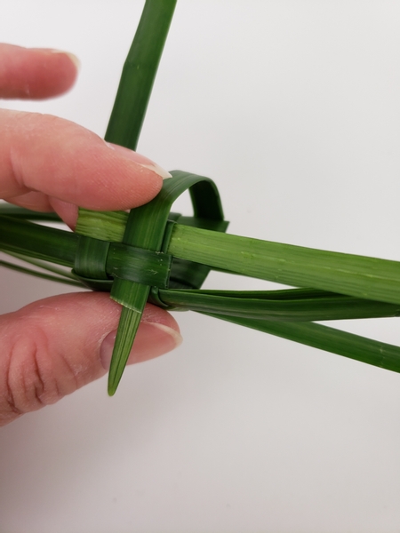 Continue the weaving pattern by folding the blade over and weave it through on the opposite end Continue the weaving pattern by folding the blade over and weave it through on the opposite end
