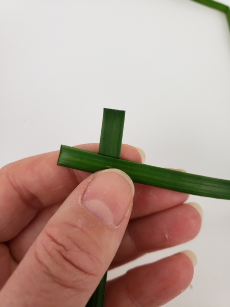 Fold a second blade of grass in half and slip it around the first blade