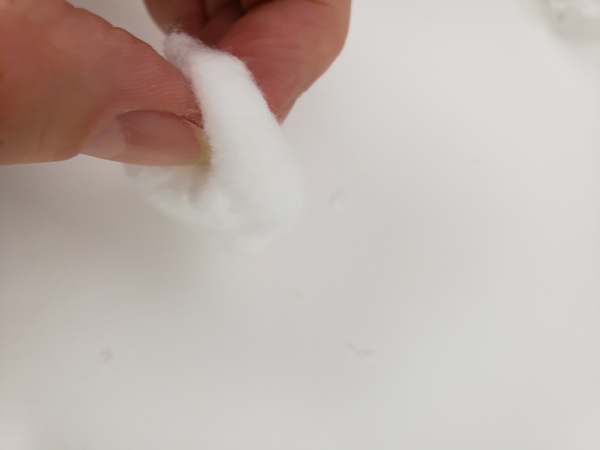 Make a hole in the middle of another cotton ball