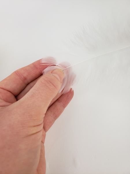 Buffer the feather with the pad of your finger from behind