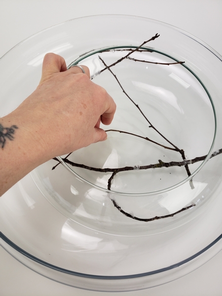 Create a dry twig design inside the vase