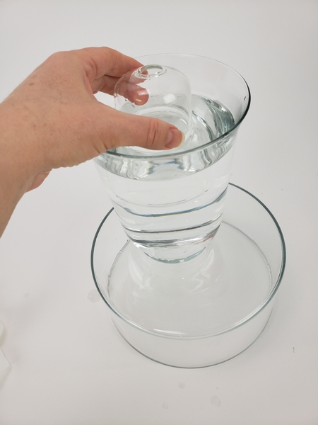 Place a smaller vase into the water filled vase so that it floats