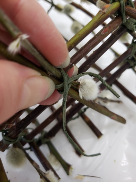 And secure the twigs to the side of the basket with a figure eight wire