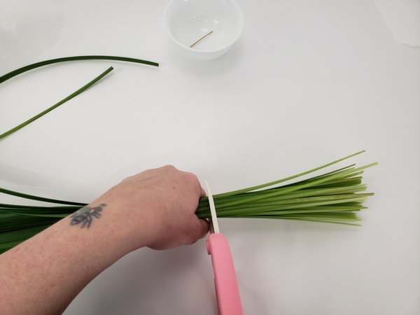 Cut away the hard ends of a bundle of grass