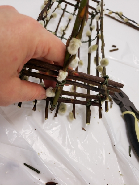 Secure the longer pussy willow twigs to the other side of the basket with wire