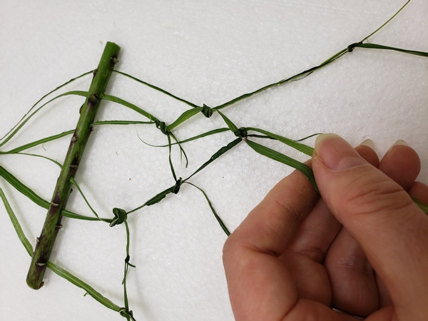 And carefully knot the strands around the pin