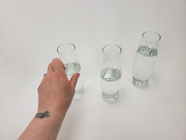 Fill a few bud vases with water and place it on your display surface