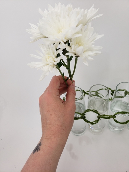 Place the flower stems in the water filled vases