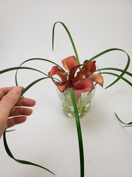 Add grasses to radiate around the vase