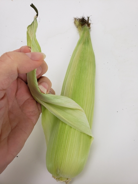Remove the corn husks of 4 ears of corn