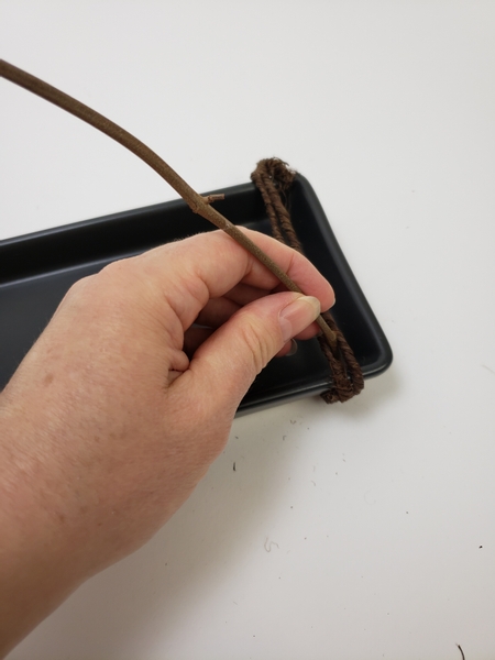 Slip a twig between the two wires so that it stands upright