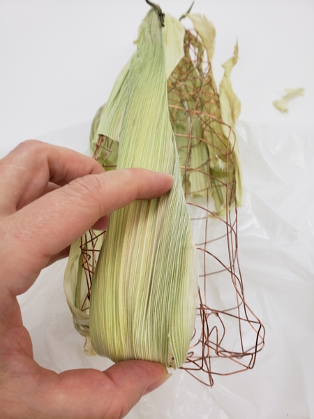 Start at the tip and stack the husks to slightly overlap moving down to the stem end