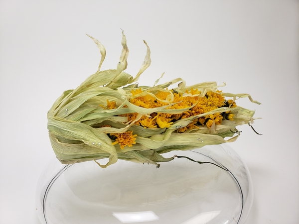 Using corn husk in a flower arrangement