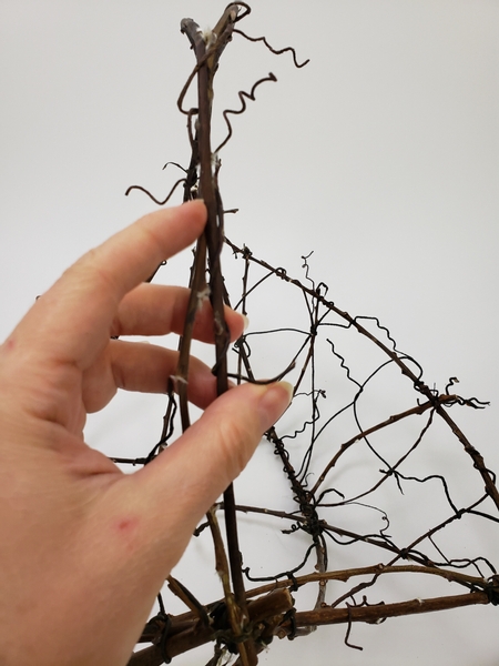 Add in another wire vine to follow over the basket to finish off the handle