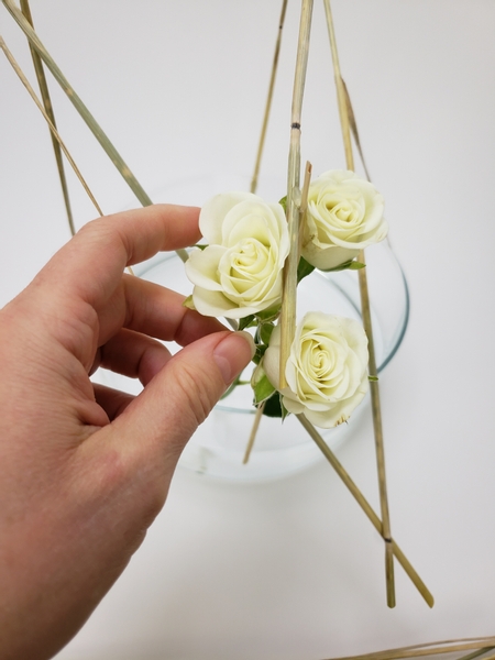 Place some spray roses between the wheat stems