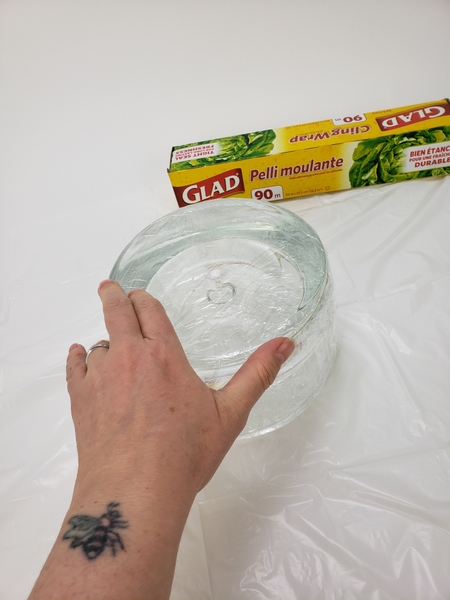 Cover a small container with plastic wrap