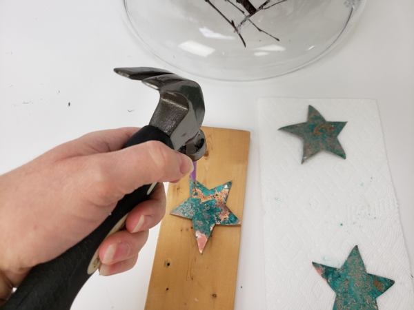 Make a small hole on one end using a hammer and a sharp object like a nail.