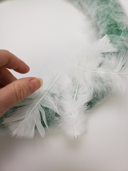 Overlap the feathers but glue them at only one spot so that they blow and reveal the layers below